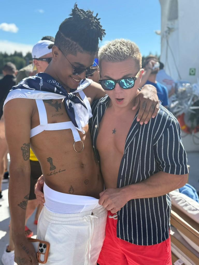 Damon reacting playfully with a Venezuelan guest at the Macho yacht party during Vancouver Pride 2026