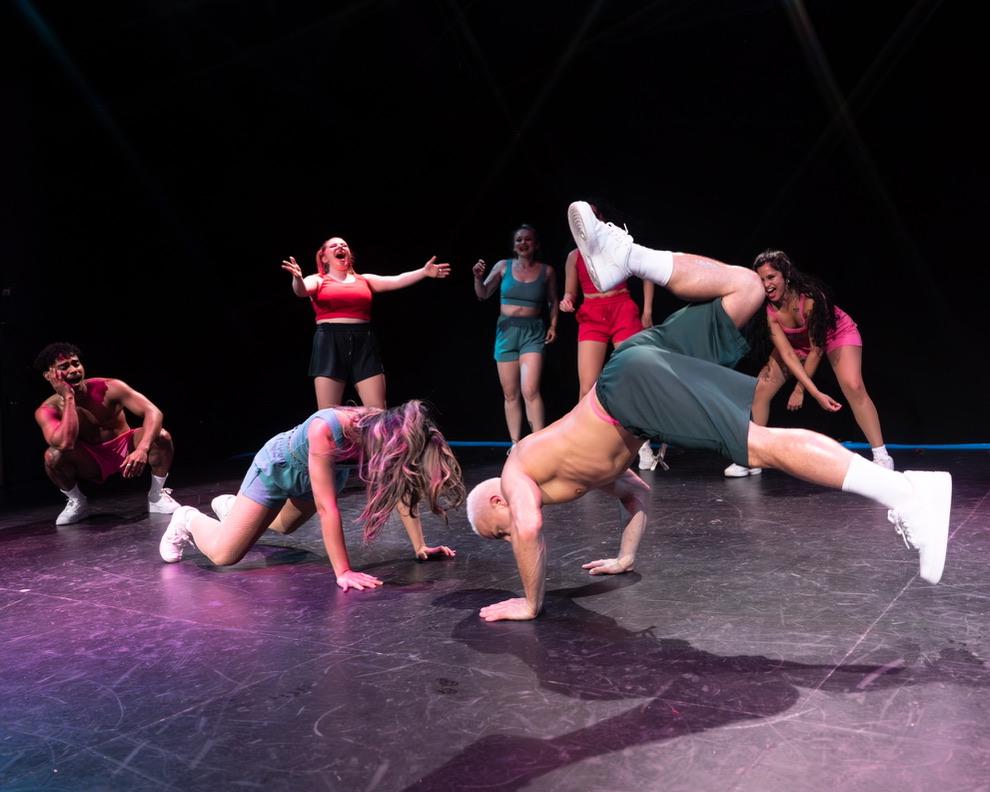 Damon performing Brazilian funk on stage with a dolphin dive move at a Vancouver theatre